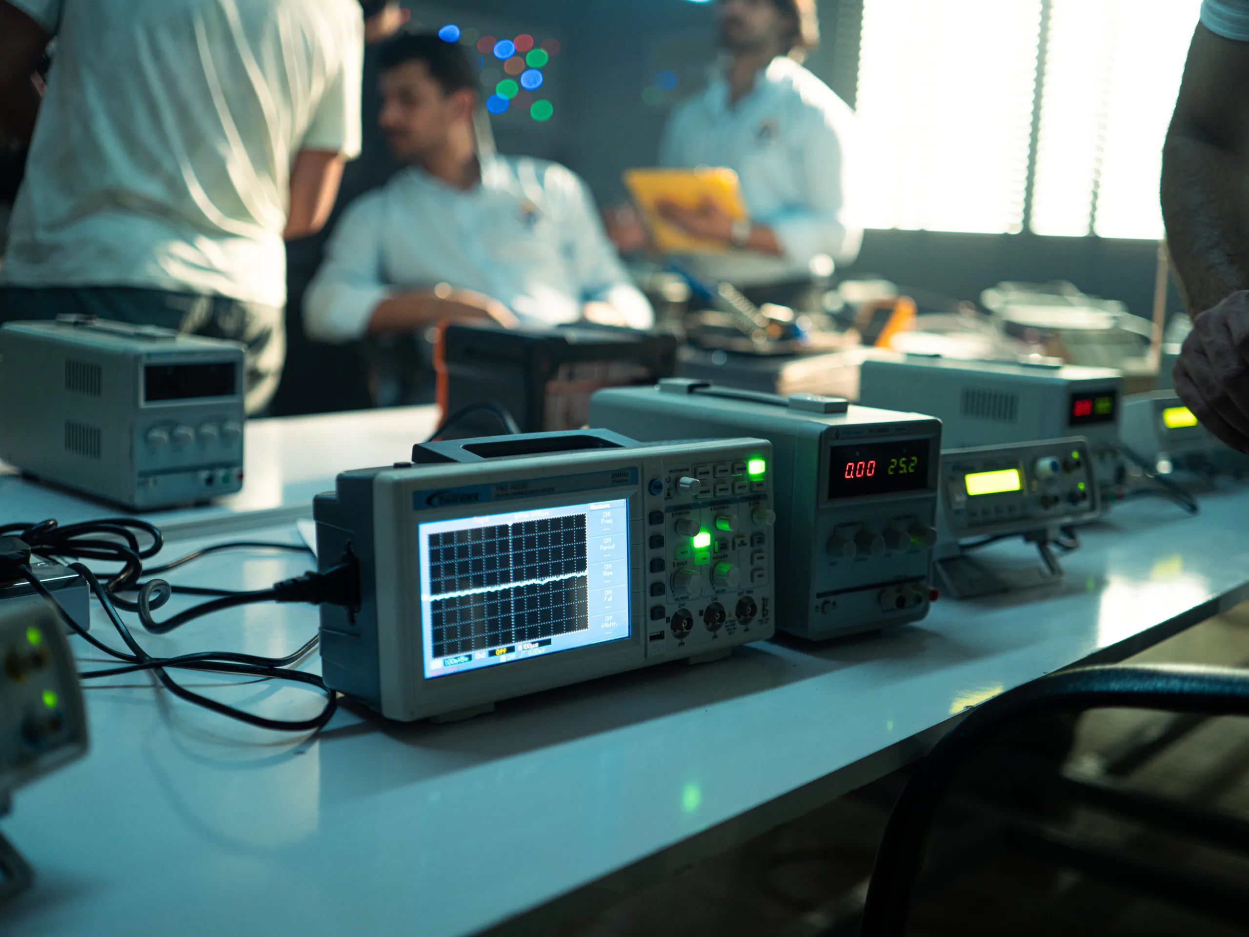 Engineers and electrical test instruments in an electronics laboratory